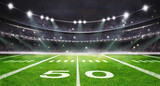 green field in american football stadium. ready for game in the midfield