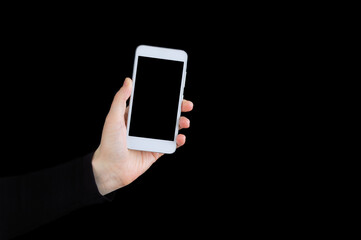 White smartphone in hand close-up on black background.