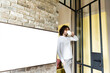 © LIGHTFIELD STUDIOS - young man in pajamas drinking coffee while standing near white lcd screen hanging on brick wall