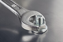 Wrench Tightens  Bolt In Steel Billet. Spanner, Bolt, Screw And Nuts.