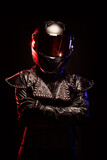 Fototapeta  - Portrait of a young female biker wearing a studded leather jacket and a black helmet