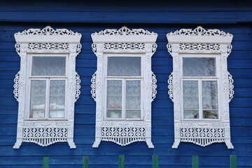 Richly decorated ornamental carved windows, frames on vintage wooden rural house in Maydakovo village, Ivanovo region, Russia. Russian traditional national style in wooden architecture. Countryside