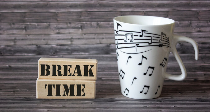 Time for a break text on blocks with a mug on a wooden table