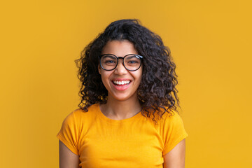 Wall Mural - Studio shot of cute african american girl on bright yellow background