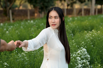 Beautiful Vietnamese girl with national costume in flower field,select focus.