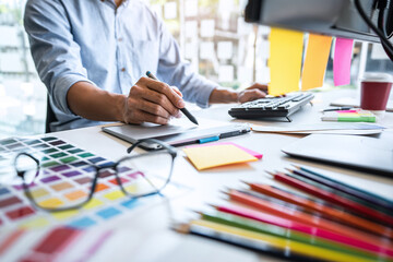 Poster - Two colleague creative graphic designer working on color selection and color swatches, drawing on graphics tablet at workplace with work tools and accessories