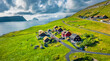 Sunny summer view from flying droneof Kirkjubour village with Hestur Island on background. Fantastic morning scene of Faroe Islands, Denmark, Europe.  Beauty of nature concept background.