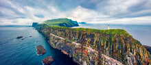 Panoramic View From Flying Drone Of Mykines Island With Old Lighthouse. Gloomy Summer Scene Of Faroe Islands, Denmark, Europe. Stunning Seascape Of Atlantic Ocean.