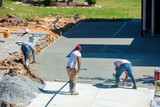 Fototapeta Miasta - Unidentifiable Hispanic men working on a new concrete driveway