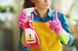 woman with raised finger and toxic cleaning supplies