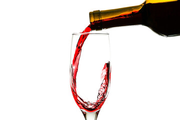 red wine is pouring into a glass from a bottle on white background