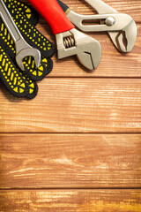 Wall Mural - Professional set of tools and work gloves for plumbers on a vintage wooden boards