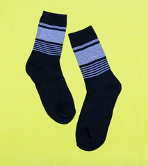 Wall Mural - A pair of black men's socks on a yellow background