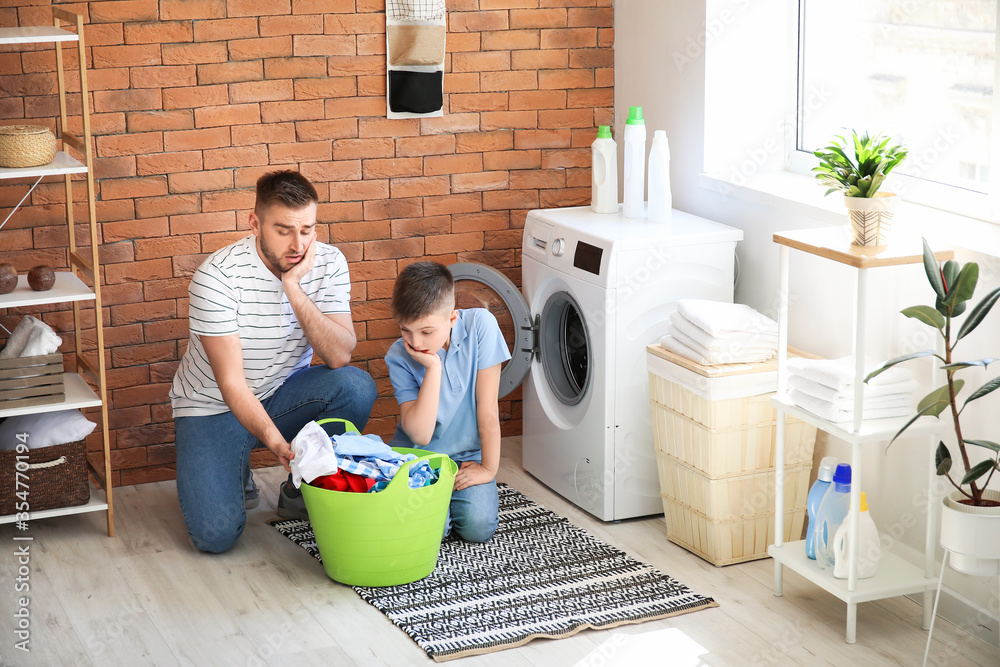 Man and his little son doing laundry at home