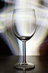 Sticker - Vertical selective focus shot of an empty wine glass with blurry lights in the background