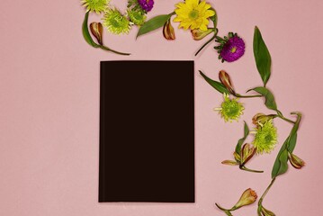 Canvas Print - High angel shot of a notebook with flowers on pink background