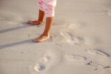 Fototapeta Morze - Legs of  happy  little girl have fun and joy time at beautiful beach