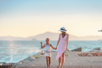 Young mother with her daughter walking at the promenade alley