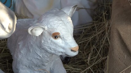 Wall Mural - lamb figurine,on a hay figurine of a lamb in a Christmas nativity scene