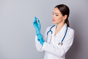 Poster - Photo of attractive family doc skilled experienced professional surgeon take on latex gloves prepare to operation wear medical uniform lab coat stethoscope isolated grey background