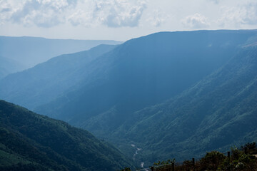 Wall Mural - Natural view of the folded mountains and lush green valleys with clear sky and clouds of Cherrapunji, Meghalaya, North East India
