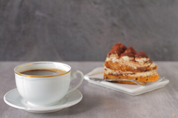 Wall Mural - A cup of coffee and a tiramisu cake on a table