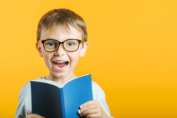child reads a book against a bright wall
