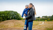 © Кирилл Рыжов - Portrait of happy smiling young mohter holding and embracing her little son on field at park