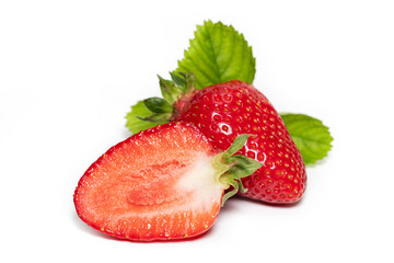 Isolated strawberries. Three fruits, one cut in half on white background