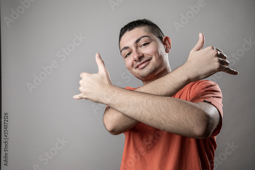 Fotografía Ragazzo giovane con t-shirt arancione balla divertito stile rapper, isolato su s