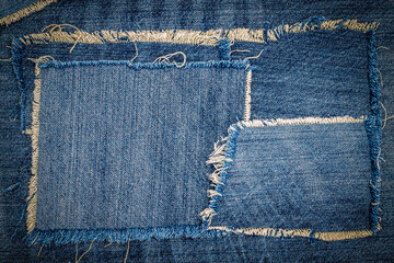 destroyed torn denim blue jeans fabric frame on blue jeans background. worn jeans casual double colo