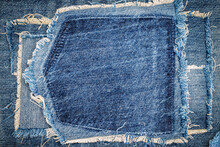 Destroyed Torn Denim Blue Jeans Fabric Frame On Blue Jeans Background. Worn Jeans Casual Double Color Patch Denim.