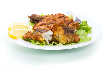 Wall Mural - fried hake fish in batter with lettuce and lemon in a plate