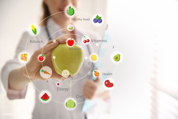 Wall Mural - Nutritionist's recommendations. Doctor with apple in office, closeup