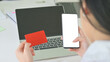 © sarawutnirothon - Credit card and smartphone in the woman hand and the laptop on the back.