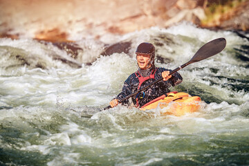 Guy in kayak sails mountain river. Whitewater kayaking, extreme sport rafting