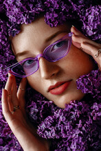 Beautiful Redhead Lady With Freckled Skin, Wearing Trendy Purple Sunglasses, Many Rings, Hides Her Face, Posing In Lilac Flowers