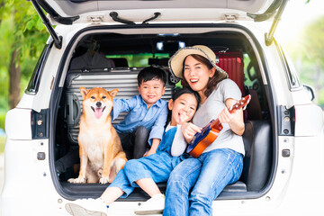 Pet lover. Happy asian children and Mother with shiba inu sitting and Sing Song in car.