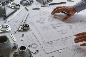 Wall Mural - Engineer technician designing drawings mechanical parts engineering Engine.manufacturing factory Industry Industrial work project blueprints measuring bearings caliper tools