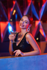 Waist up portrait of elegant stylish beautiful sexy brunette caucasian woman with hairstyle relaxing and having fun at party at night club. Fashionable girl. Colorful light