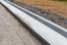 Road Construction Details, Extruded Concrete Curb Beside Freshly Prepared Road Bed, Horizontal Aspect