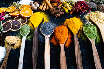 Many multi colored spices and dried fruits on the table