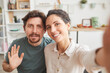 © AnnaStills - Portrait of young couple smiling at camera they making selfie at home