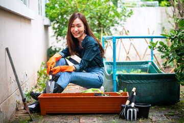 portrait of Asian woman gardening her home vegetable garden at home