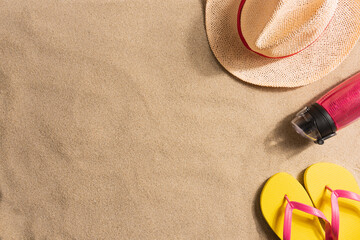 Wall Mural - Summer vacation composition. Water bottle, flip flops and straw hat on sand