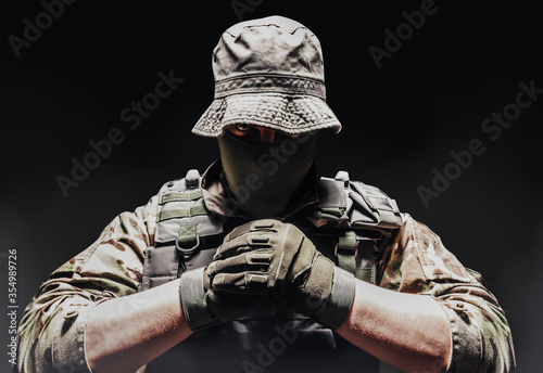 Fotografía Fully equipped soldier in panama hat, armor vest and tactical gloves