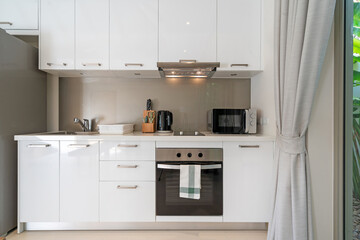 Interior design of kitchen in luxury villa, apartment feature kitchen counter, refrigeratpr, oven, hood and microwave