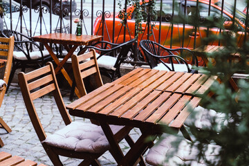 View on summer terrace of restaurant , bar, cafe with wooden tables and flowers. Beautiful terrace , outdoor summer cafe.