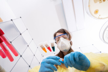 Canvas Print - Young woman with a microtube for PCR test