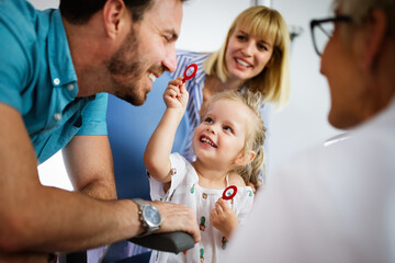 Ophthalmologist is checking the eye vision of little cute girl in modern clinic.